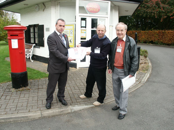 Phil  Rippingale and Mike Hallas present the dossier to Mark Partington